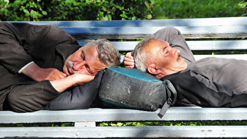 Мужчины спят на скамейке на Тверском бульваре в Москве